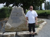 Motorcyclist standing next to stone which is centre of Germany